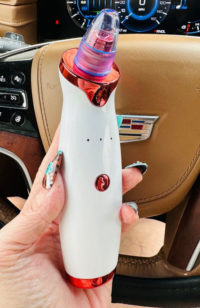 Hand holding a white and red device with a car interior background